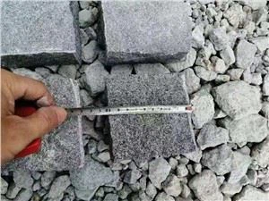 Tmavě šedé žulové kostky dlažby a terénní úpravy